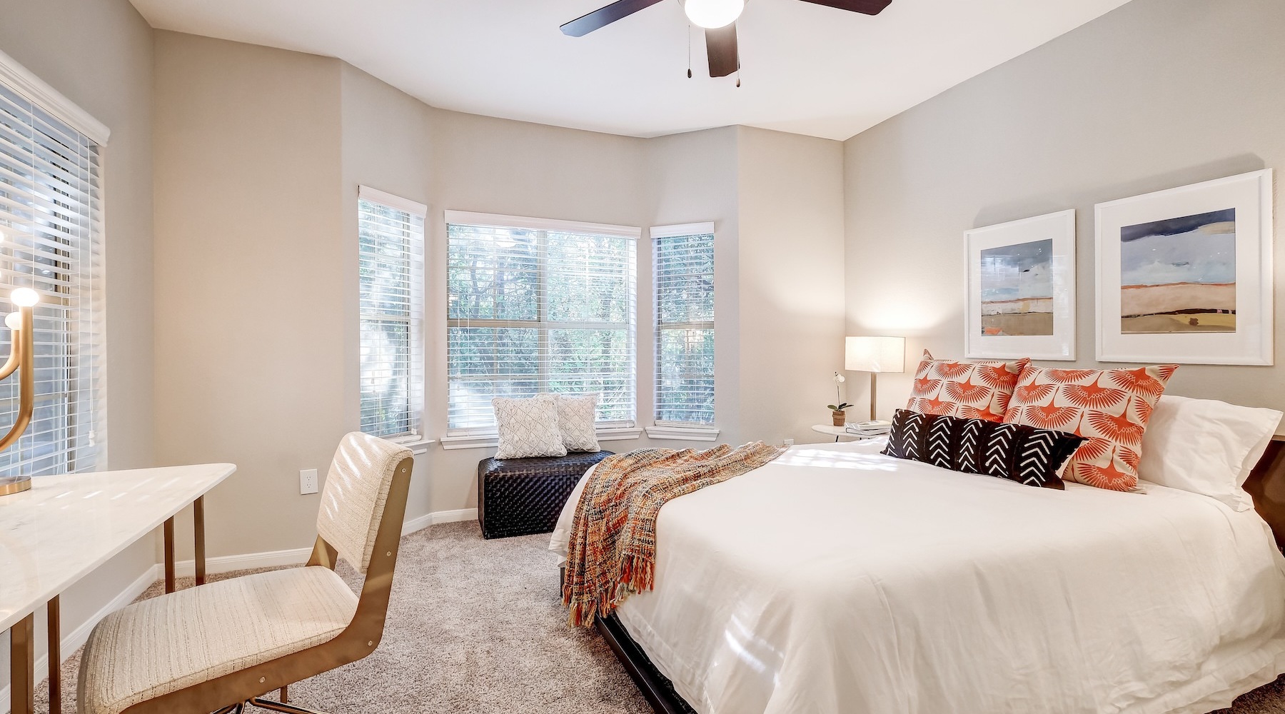 Generous bedroom offerings to fit every family a bedroom with a nightstand, desk and a window