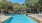 a swimming pool with trees and a building in the background