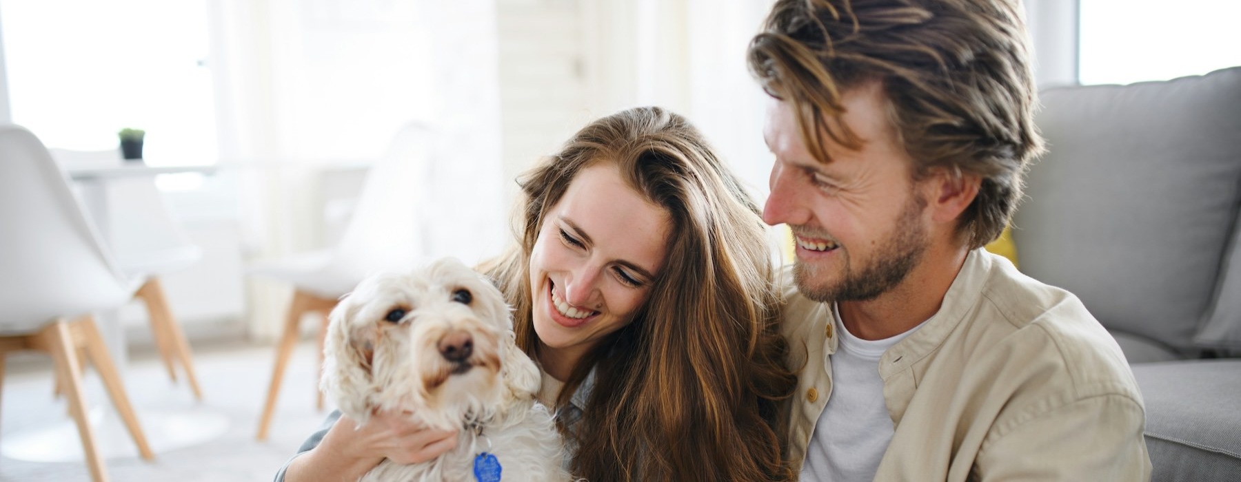 a man and woman sitting on a couch with a dog