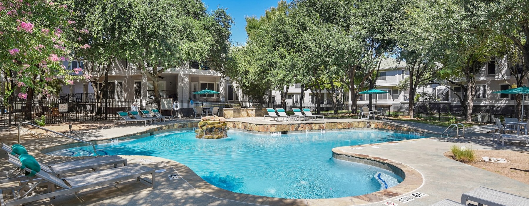 a swimming pool with chairs and trees