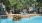 a pool with a stone wall and trees around it